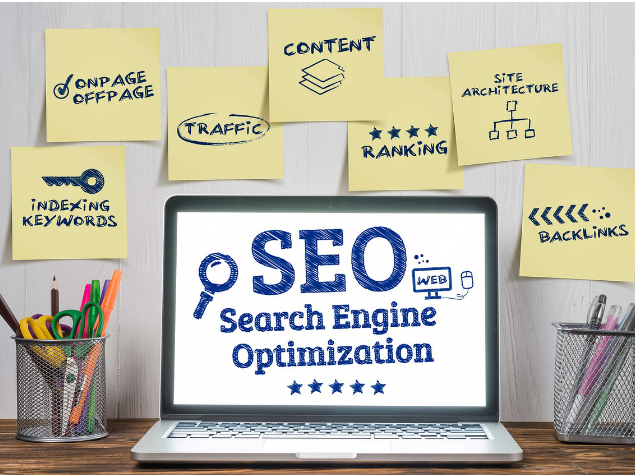 SEO on laptop surrounded by post it notes that say things like Backlinks, Indexing keywords, ranking, site architecture, content.